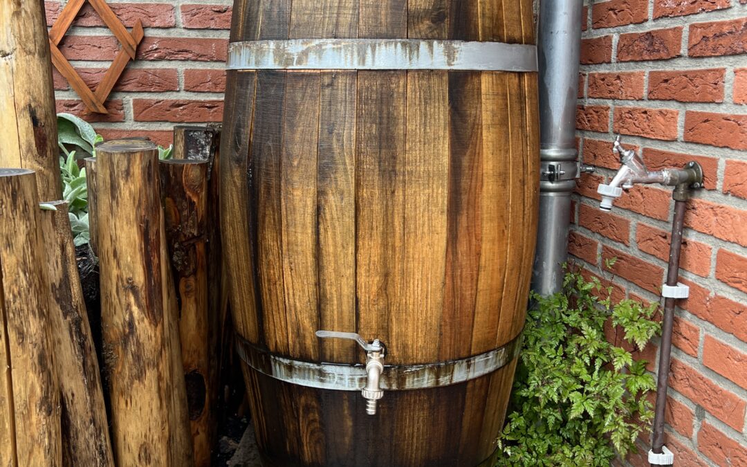 Een houten regenton die een klein beetje lekt